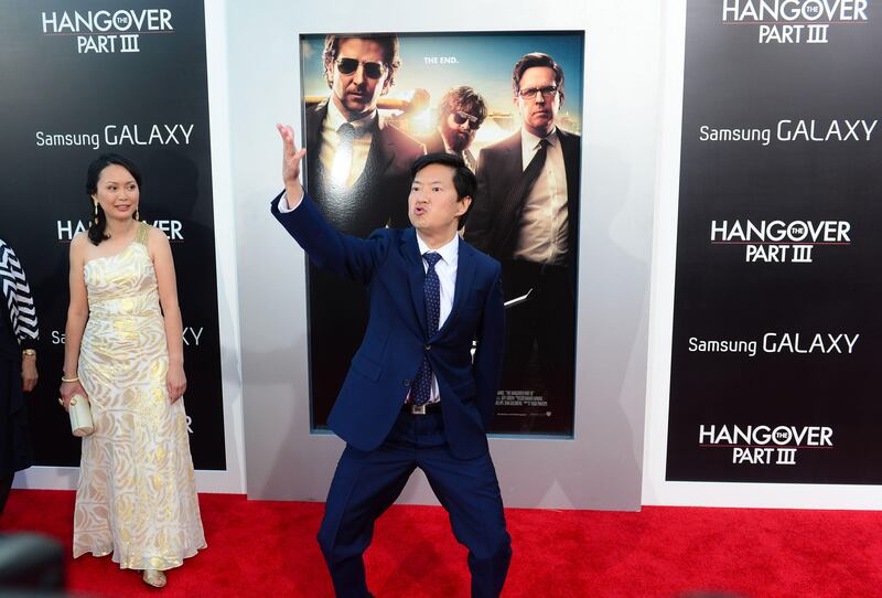 Ken Jeong mimicks a moment self gratification as his wife watches while posing on arrival for the Los Angeles premiere of the film 'The Hangover Part 3' in Los Angeles, California on May 20, 2013. The film opens nationwide on May 23. AFP PHOTO/Frederic J. BROWN
 *** Local Caption ***  162176-01-08.jpg