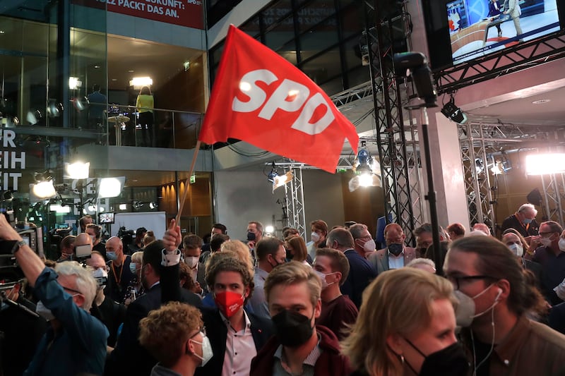 A supporter waves an SPD a flag at party headquarters in Berlin. AP