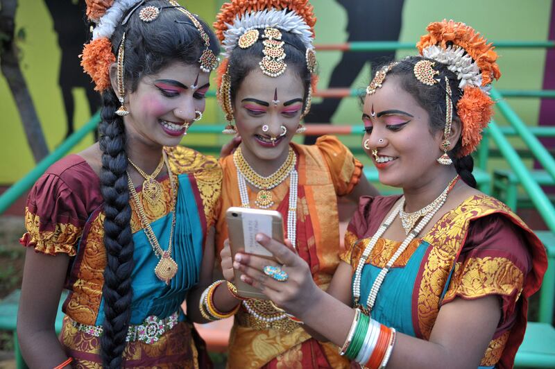 Indian girls look at a mobile phone  in Secunderabad. Noah Seelam / AFP Photo