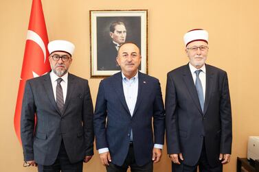 Turkish Foreign Minister Mevlut Cavusoglu, centre, meets Muslim clerics Ahmet Mete, left, and Ibrahim Serif in Komotini, Greece. Reuters