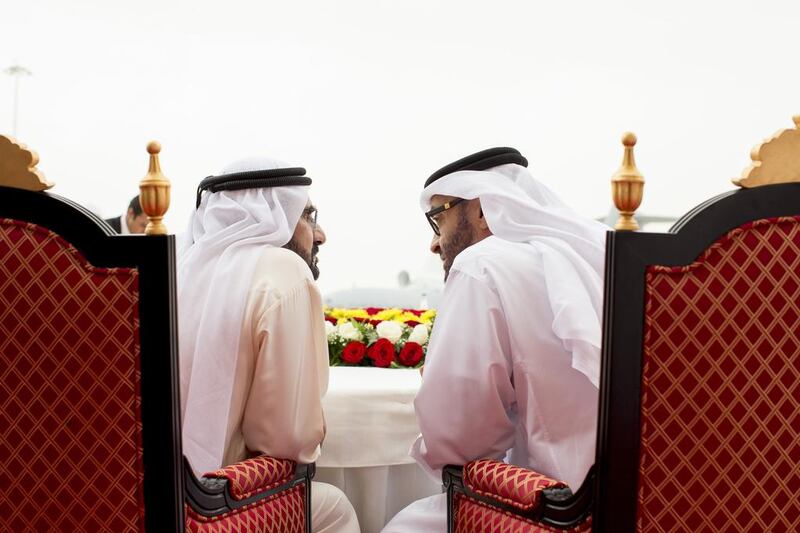 Sheikh Mohammed bin Rashid, Vice President and Ruler of Dubai, chats with Sheikh Mohammed bin Zayed, Crown Prince of Abu Dhabi and Deputy Supreme Commander of the Armed Forces, as they watch a display while touring the Dubai Airshow on its opening day yesterday. Ryan Carter / Crown Prince Court – Abu Dhabi