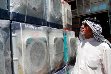A customer looks at Iranian-made washing machines at a shop in Baghdad. AFP