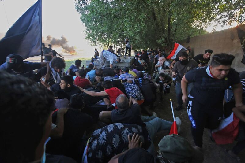 Iraqi protesters flee from security forces during a demonstration against state corruption, failing public services, and unemployment, in the Iraqi capital Baghdad's central Khellani Square. AFP