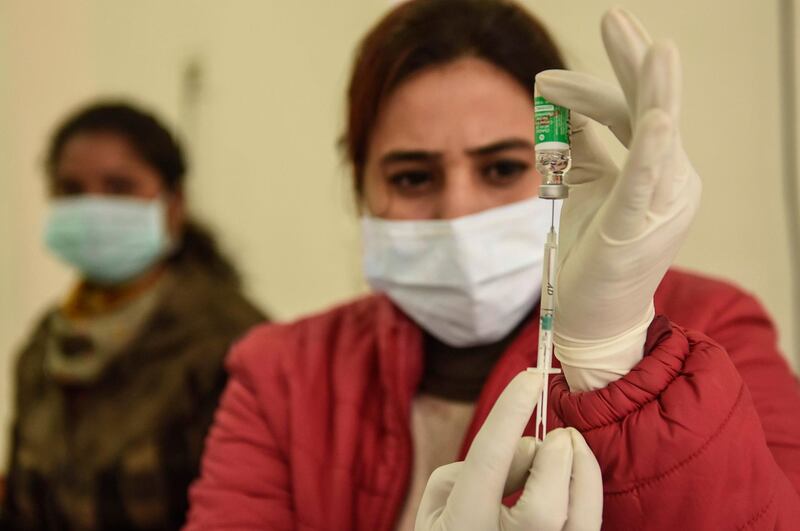 A medical worker prepares to inoculate a woman with a Covid-19 coronavirus vaccine at the Civil hospital in Amritsar on January 27,2021 / AFP / NARINDER NANU
