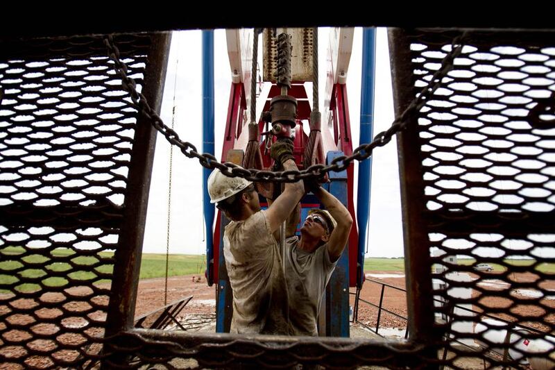 Above, workers on a US oil derrick in North Dakota. Gregory Bull / AP Photo