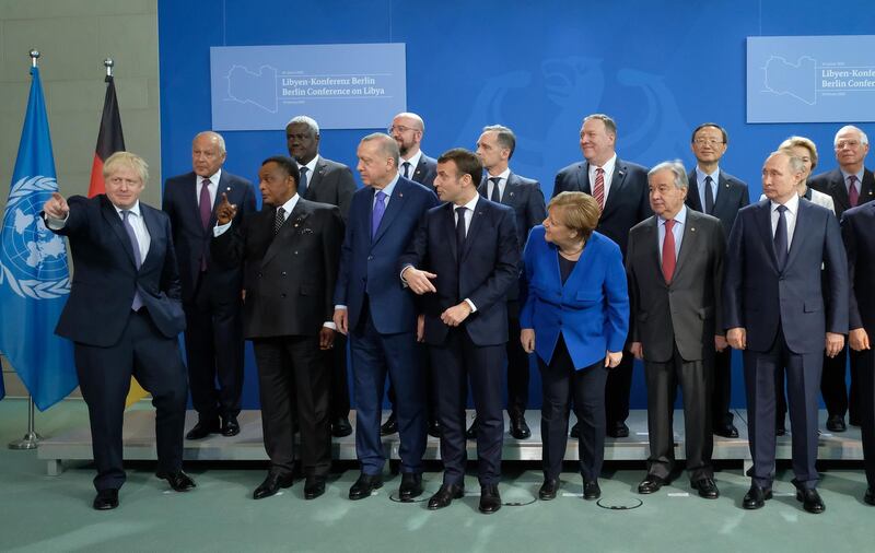 BERLIN, GERMANY - JANUARY 19: British Prime Minister Boris Johnson (L) gestures as other participants, including German Chancellor Angela Merkel, French President Emmanuel Macron, Russian President Vladimir Putin, U.S. Secretary of State Mike Pompeo and Turkish President Recep Tayyip Erdogan, look before a group photo at an international summit on securing peace in Libya at the Chancellery on January 19, 2020 in Berlin, Germany. Leaders of nations and organizations linked to the current conflict are meeting to discuss measures towards reaching a consensus between the warring sides and ending hostilities.   (Photo by Sean Gallup/Getty Images)