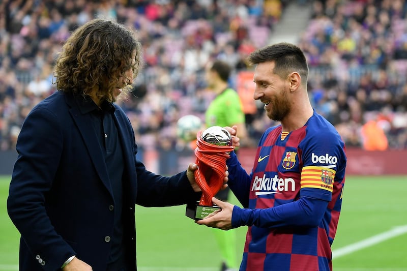 Lionel Messi  receives La Liga best player of the month award from former Barca star Carles Puyol. AFP