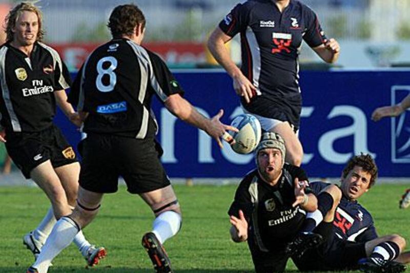 Dubai Hurricanes, pictured in black playing Dubai Dragons, are fighting to keep the Gulf Top Six trophy.
