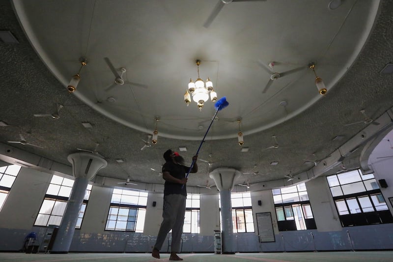 A worker cleans the ceiling of a deserted mosque before reopened after nearly three months of lockdown amid the coronavirus pandemic in Colombo, Sri Lanka. EPA