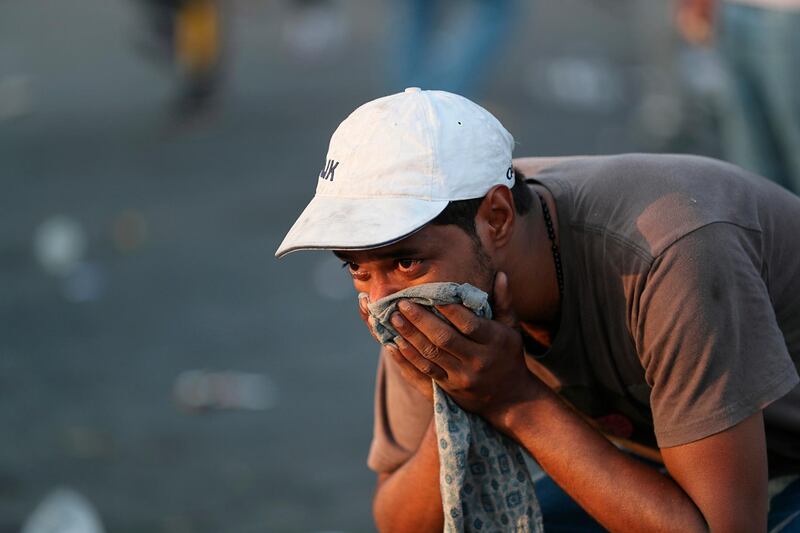 A man covers his face from tear gas fired by security forces in Baghdad. AP Photo