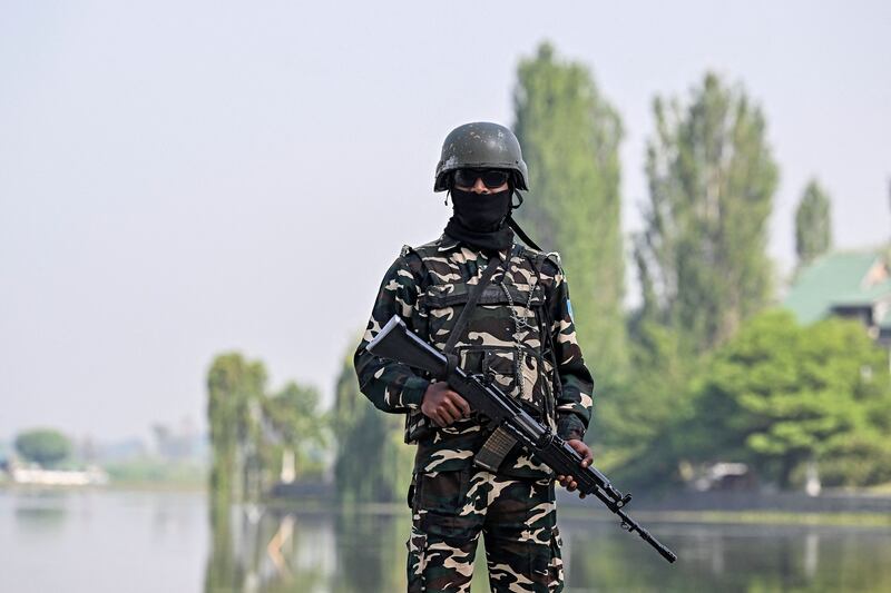 An Indian soldier stands guard on the shores of Dal lake outside a vote-counting station in Srinagar. AFP