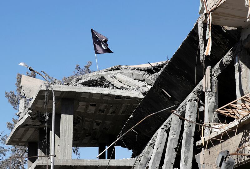 A flag of Islamic State militants is pictured above a destroyed house near the Clock Square in Raqqa, Syria October 18, 2017. Picture taken October 18, 2017.     REUTERS/Erik De Castro