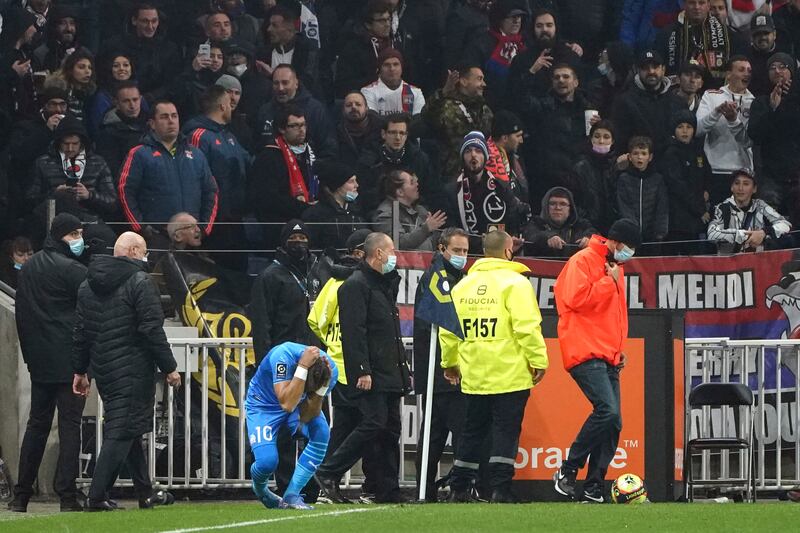 Marseille's Dimitri Payet goes down after being struck by a water bottle thrown by a Lyon supporter. AP