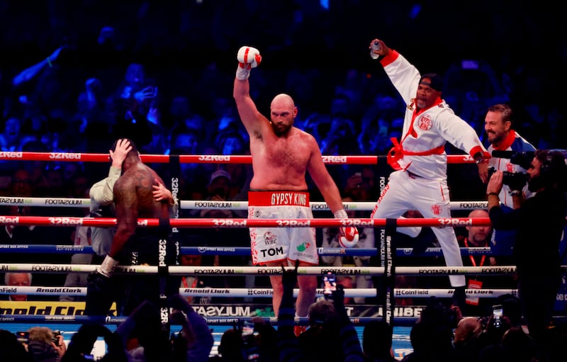 Tyson Fury celebrates his knockout win over Dillian Whyte to retain his WBC heavyweight title at Wembley Stadium on Saturday, April 23, 2022 as referee Mark Lyson supports Whyte on the ropes. Reuters