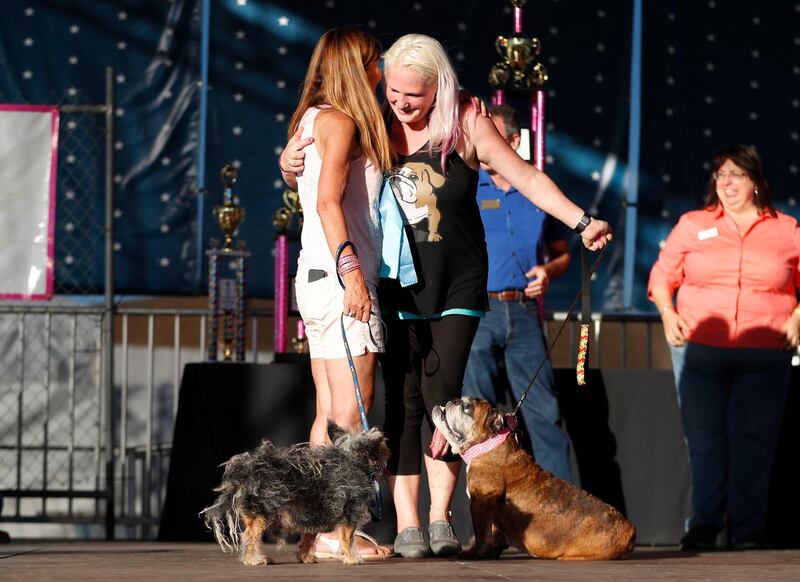 Megan Brainard, right, from Minnesota, and her dog Zsa Zsa, an English Bulldog and Yvonne Morones and her dog Scamp, a mix breed, hug just before the winner of the World's Ugliest Dog Contest winner is announced. Monica M. Davey / EPA