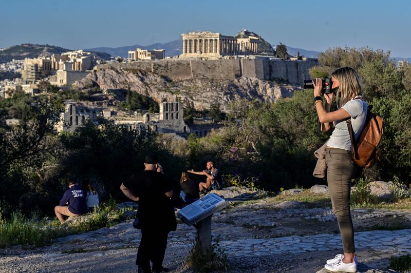 Tourists enjoy the view of the Acropolis in Athens. The Greek capital is one of the most-searched destinations for Eid Al Adha by UAE residents. AFP