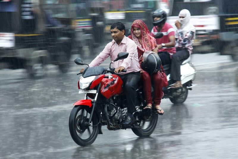 A couple riding a motorcycle brave the monsoon rains in Gurgaon, India. Manoj Kumar / Hindustan Times via Getty Images