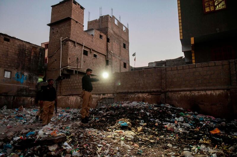 TOPSHOT - In this picture taken on October 19, 2020 police officer Shakir Hussain (C) uses his mobile's torch to light the site where the body of Marwah, a five-year-old girl who was raped and murdered, was found in Pakistan's port city of Karachi.
 Marwah was on her way to buy sweets in the early hours of the morning when she was kidnapped, raped and then killed in a popular area of Karachi. - To go with 'PAKISTAN-CHILDREN-RAPE-MURDER' FOCUS by Joris FIORITI
 / AFP / Asif HASSAN / To go with 'PAKISTAN-CHILDREN-RAPE-MURDER' FOCUS by Joris FIORITI
