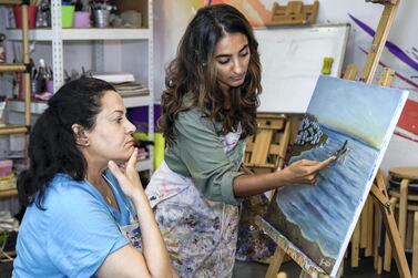 Art teacher Asareh Ebrahimpour with student Haifa Salama at the school. Victor Besa / The National 