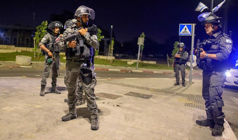 Israeli security forces are seen in a street in Lod near Tel Aviv, on May 12, 2021, after rockets were launched towards Israel from the Gaza Strip controlled by the Palestinian militant group Hamas. Palestinian militant group Hamas said on May 12 it had fired more than 200 rockets into Israel in retaliation for strikes on a tower block in Gaza. / AFP / AHMAD GHARABLI
