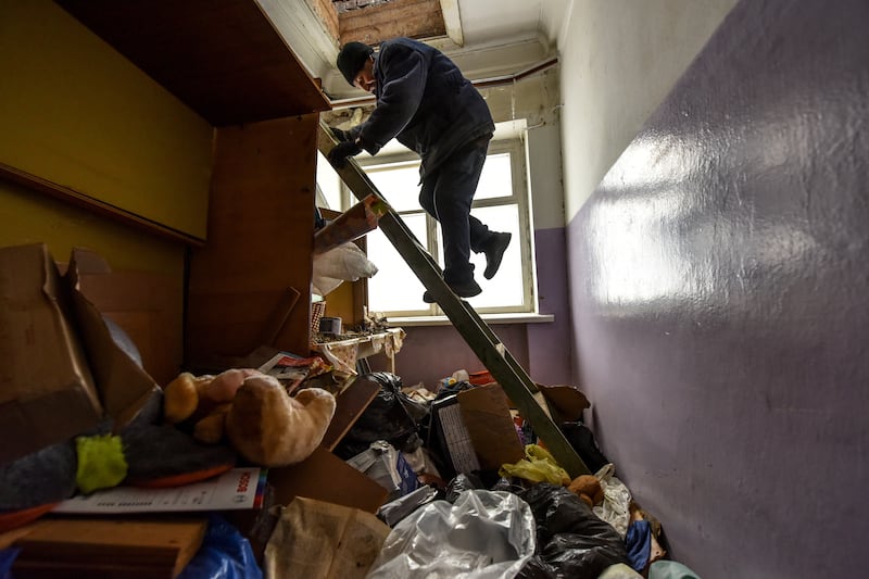 A resident clears up a house that was occupied by Russian soldiers in Yahidne. EPA