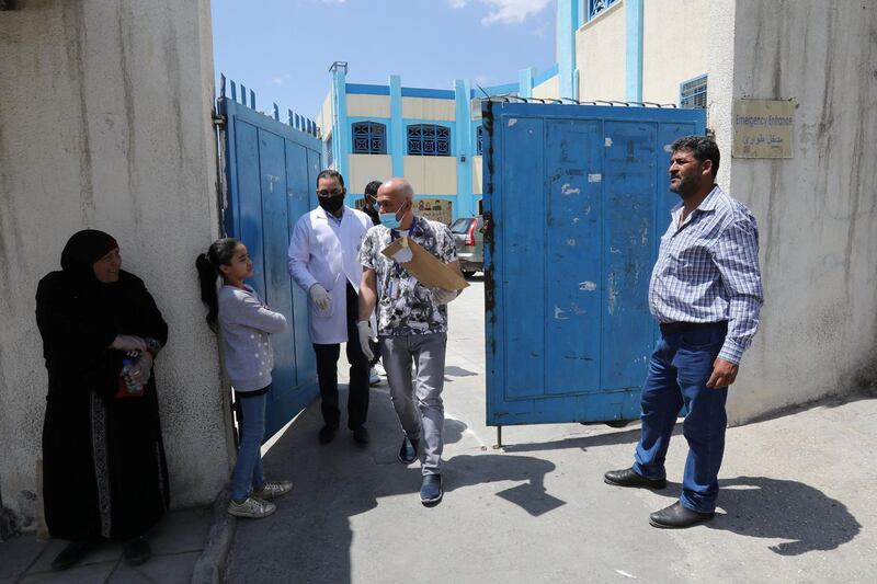 Palestinian refugees wait in front of the Al Wehdat camp health centre to register their names to get medication amid concerns over the spread of the coronavirus disease. Reuters