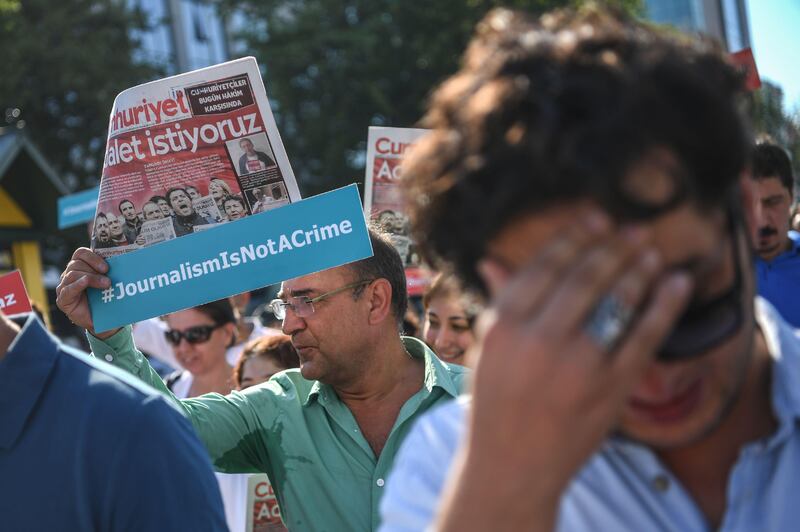 Journalists hold  banners and copies of Cumhuriyet daily reading "We want Justice" as they march to the courthouse from Cumhuriyet daily's headquarters on July 24, 2017 in Istanbul.
Seventeen directors and journalists from one of Turkey's most respected opposition newspapers go on trial on July 24 after spending over eight months behind bars in a case which has raised new alarm over press freedoms under President Recep Tayyip Erdogan. / AFP PHOTO / OZAN KOSE