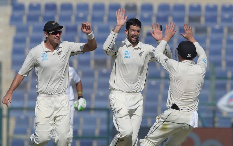 New Zealand spinner Will Somerville (C) celebrates with teammates Tim Southee (L) and Henry Nicholls after taking the wicket of Pakistani batsman Haris Sohail during the last day of the third and final Test cricket match between Pakistan and New Zealand at the Sheikh Zayed International Cricket Stadium in Abu Dhabi on December 7, 2018. / AFP / AAMIR QURESHI
