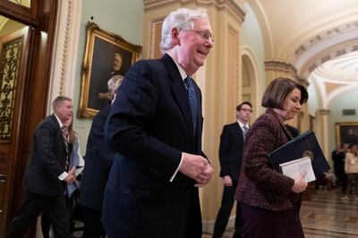 Senate Majority Leader Mitch McConnell, R-KY., walks out of the Senate chamber with Sen. Amy Klobuchar, D-Minn., during a break in the impeachment trial of President Donald Trump at the Capitol, Wednesday, Jan. 22, 2020, in Washington. (AP Photo/Steve Helber)