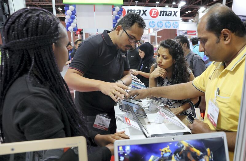DUBAI,  UNITED ARAB EMIRATES , SEPTEMBER 24 – 2019 :- Visitors looking the laptops, ipads and other electronic items at the Emax electronic stand during the Gitex Shopper held at Dubai World Trade Centre in Dubai. ( Pawan Singh / The National ) For News. Story by Patrick