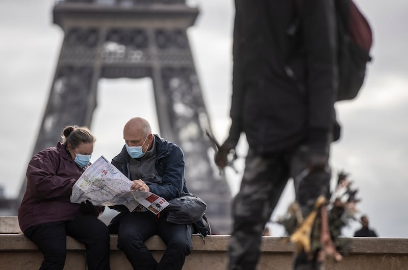 People wear protective face masks near the Eiffel Tower in Paris, France. EPA