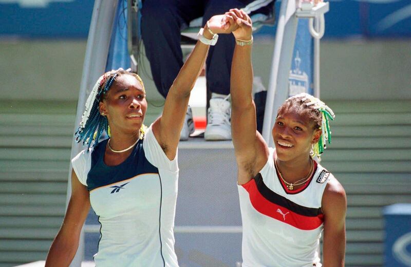 FILE - In this Jan. 21, 1998, file photo, Venus Williams, left, and sister Serena raise their arms after their center court match at the Australian Open Tennis Championships in Melbourne, Australia. Venus won the match 7-6, 6-1. Back when Serena Williams, then 16, and Venus Williams, then 17, played each other on tour for the very first time in January 1998, no one possibly could have known it would signal the start of a series that would last for two decades. (AP Photo/Rick Stevens, File)