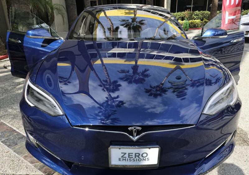 A Tesla Model S on display in downtown Los Angeles. Tesla Motors has reported a rare profit for the third quarter, while Ford's earnings have plunged. Richard Vogel / AP