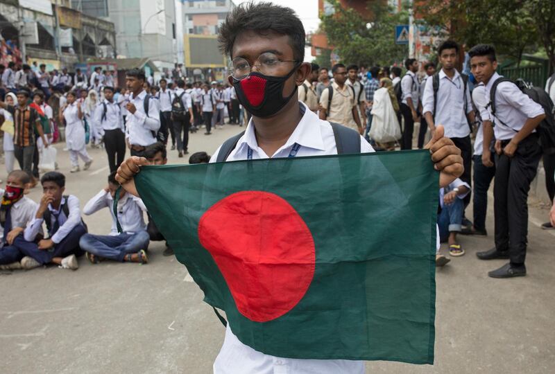 A Bangladeshi student holds a national flag and animates people to join the 'Safe roads movement' during a rally demanding safe roads on the seventh consecutive day of protests, in Dhaka city, Bangladesh.  EPA / MONIRUL ALAM