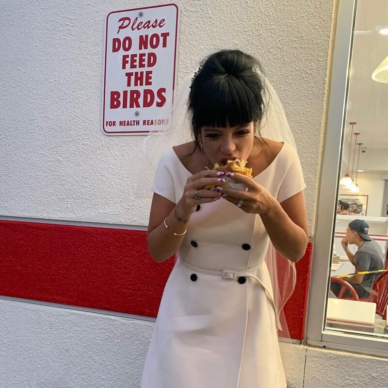 Lily Allen tucking into an In-N-Out burger in her Dior wedding dress. Instagram / Lily Allen 