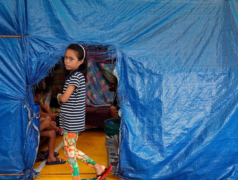 A Filipino girl is seen next to a shelter inside a gymnasium, turned into a temporary evacuation center, in Paranaque, Philippines. EPA