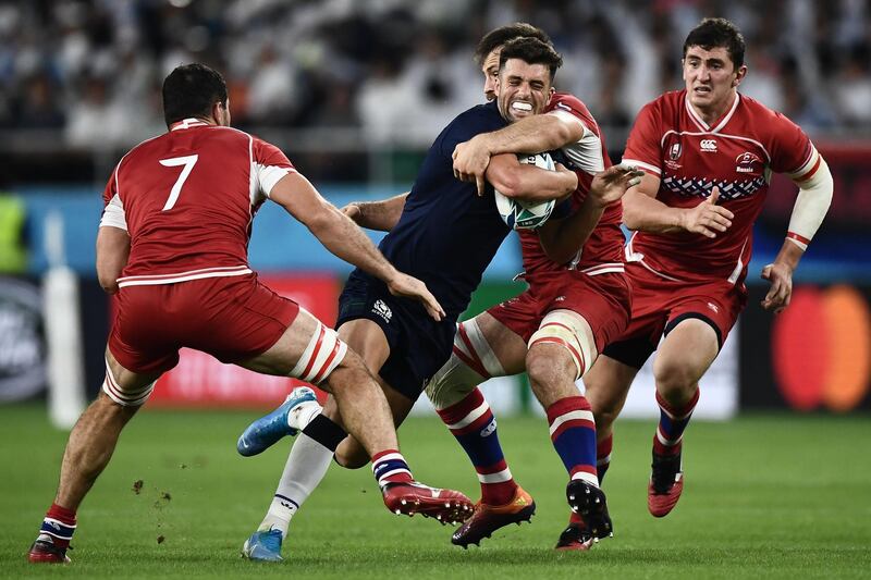Scotland's fly-half Adam Hastings (C)  is tackled by Russia's flanker Vitaly Zhivatov (2R)  during the Japan 2019 Rugby World Cup Pool A match between Scotland and Russia at the Shizuoka Stadium Ecopa in Shizuoka. AFP