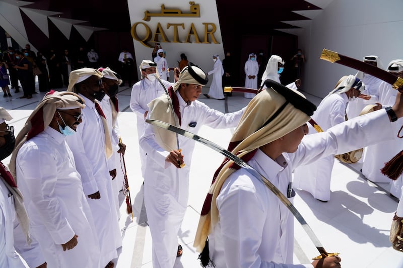 Qataris take part in a traditional sword dance at the opening of the Qatar pavilion at Expo 2020. AP Photo / Jon Gambrell