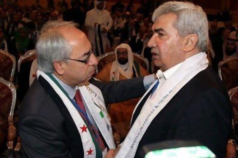 Syrian regime opponent Riad Seif, right, shakes hands with Syrian National Council (SNC) chief Abdel Basset Seda during the meeting of the General Assembly of the Syrian National Council in Doha yesterday.