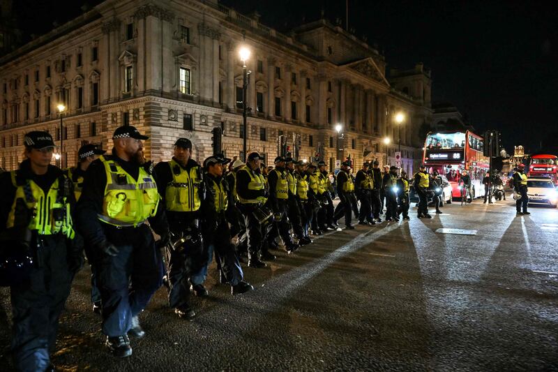 Police officers patrol Parliament Square with far-right counter-protesters nearby