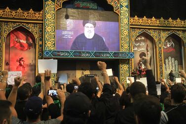 Hezbollah supporters react with clenched fists as they watch a speech by leader Hasan Nasrallah, transmitted on a large screen in south Beirut. AFP