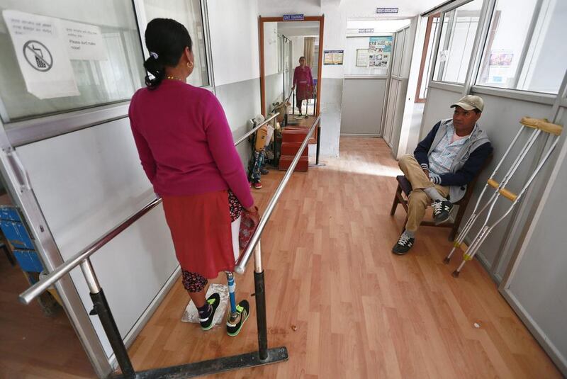 Dan Maya Maharjan, looks in a mirror in the Orthopedic rehabilitation center in Kathmandu, Nepal.  Narendra Shrestha / EPA