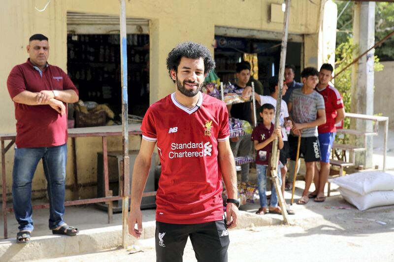 Iraqi footballer Hussein Ali, who plays for the Iraqi Al-Zawraa FC and is a lookalike of Liverpool's Egyptian forward Mohamed Salah, poses for pictures in the capital Baghdad, on June 4, 2018. - With his black beard, curly hair and football shirt, Iraqi striker Hussein Ali is often mistaken for one of the world's top players: Egypt's Mohamed Salah. (Photo by SABAH ARAR / AFP)