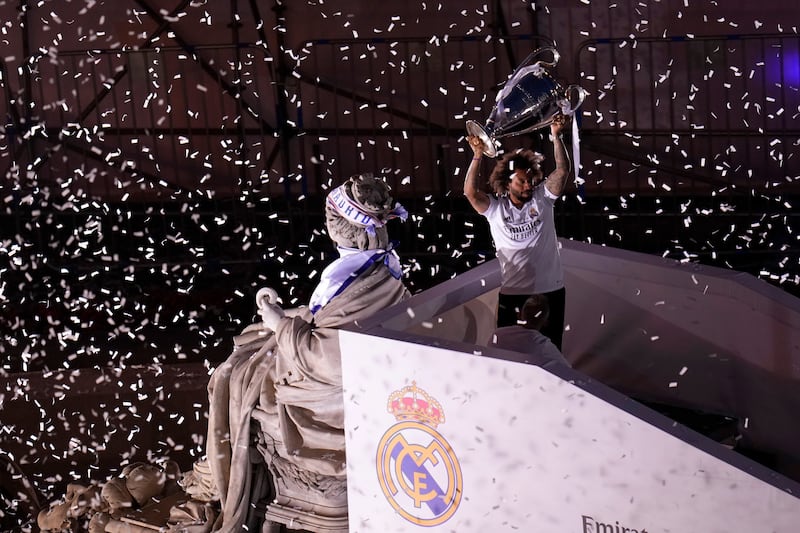 Real Madrid player Marcelo holds the trophy next to the Cibeles statue during the trophy parade. AP