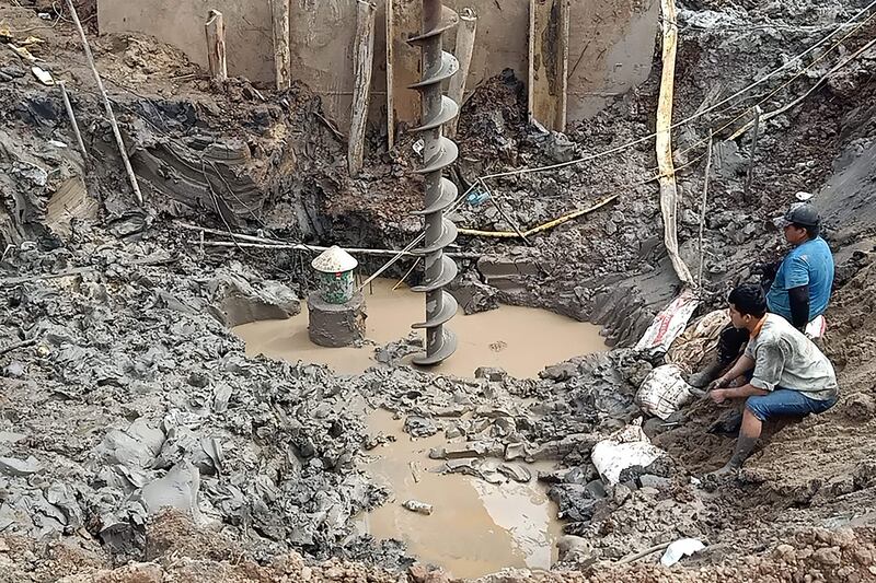 Rescuers gather at the spot where a boy fell into a 35-metre-deep shaft at a bridge construction site in Vietnam. AFP