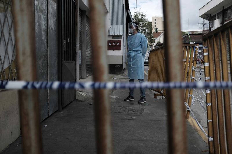 Police officers and personnel of the ministry of health inspect a room rental centre where a person died after contracting Covid-19, in San Jose, Costa Rica.  EPA