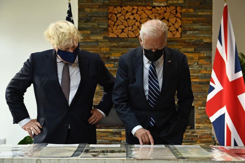 Britain's Prime Minister Boris Johnson (L) and US President Joe Biden, both wearing face coverings due to Covid-19, view a display ahead of their a bi-lateral meeting at Carbis Bay, Cornwall on June 10, 2021, ahead of the three-day G7 summit being held from 11-13 June.  G7 leaders from Canada, France, Germany, Italy, Japan, the UK and the United States meet this weekend for the first time in nearly two years, for the three-day talks in Carbis Bay, Cornwall. - 
 / AFP / Brendan Smialowski
