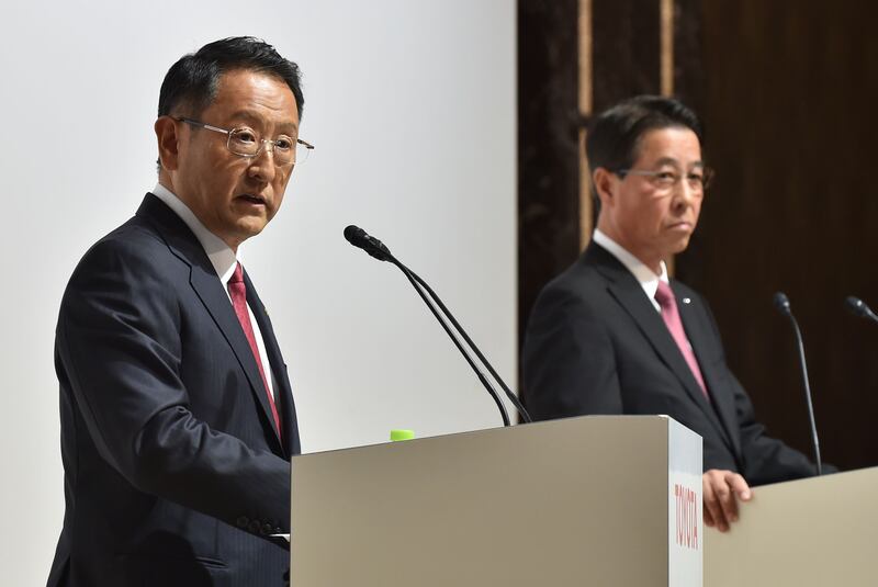 Toyota Motor Corporation President Akio Toyoda (L) answers questions as Mazda Motor Corporation President and CEO Masamichi Kogai (R) looks on during their joint press conference at a hotel in Tokyo on August 4, 2017.  
Japanese auto giant Toyota and smaller rival Mazda said August 4 they agreed a capital tie-up to focus on joint development of electric vehicles, while building a 1.6 billion USD factory in the United States which will create up to 4,000 jobs. / AFP PHOTO / Kazuhiro NOGI