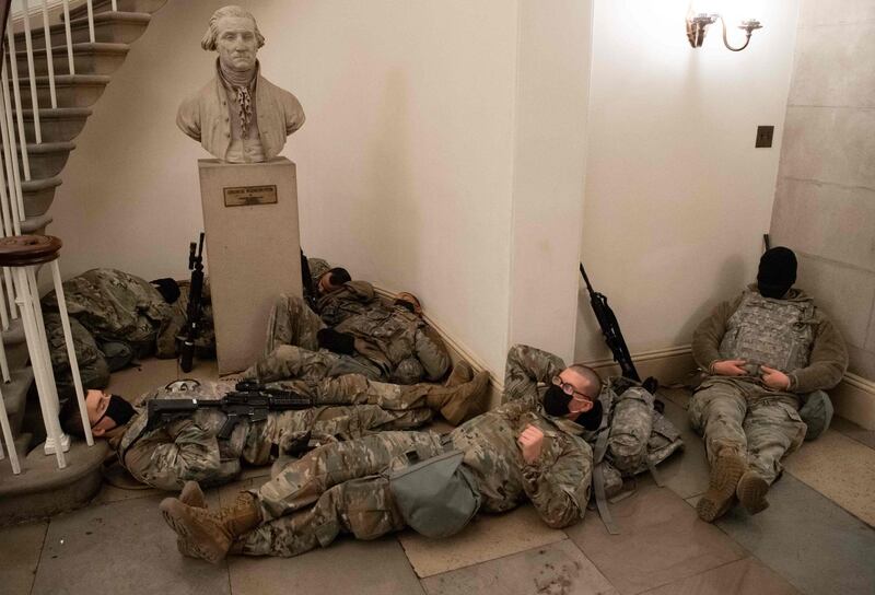 Members of the National Guard take a rest in the Rotunda of the US Capitol in Washington, DC.  AFP