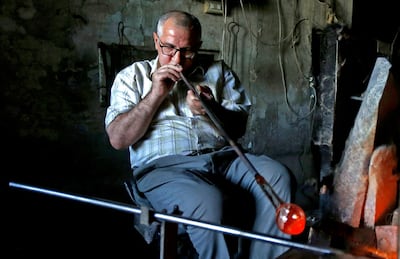 A worker at a glassblowing workshop in Damascus. AFP